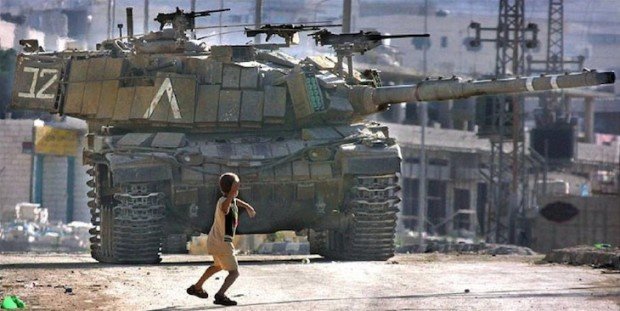 Palestinian child throwing stone at Israeli tank