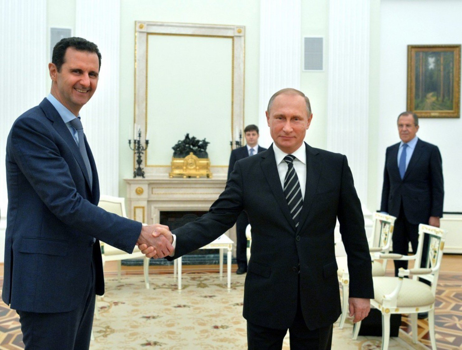 Vladimir Putin (R) shakes hands with Syrian President Bashar al-Assad
