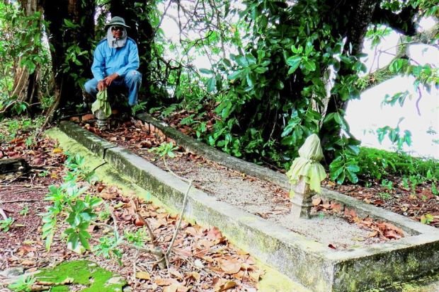 Giant skeleton in Malaysia: Mohd Fuad’s assistant Azman Wahab ﻿at the large grave site in Pulau Upeh