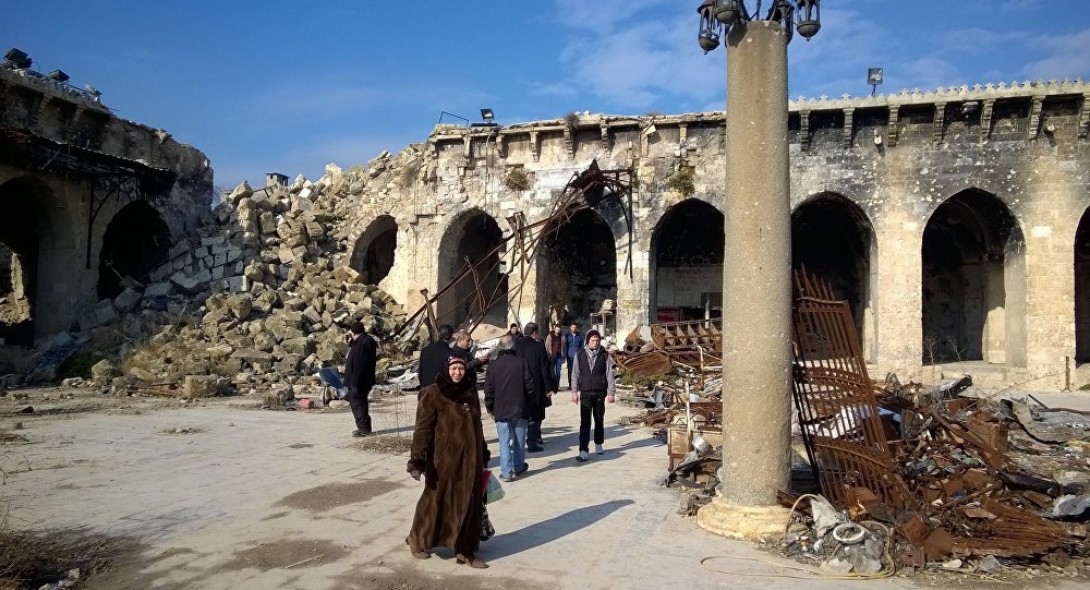 Citizens at a yard of the Umayyad Mosque of Aleppo destroyed following military actions. The Umayyad Mosque was the largest and the oldest mosque of Aleppo