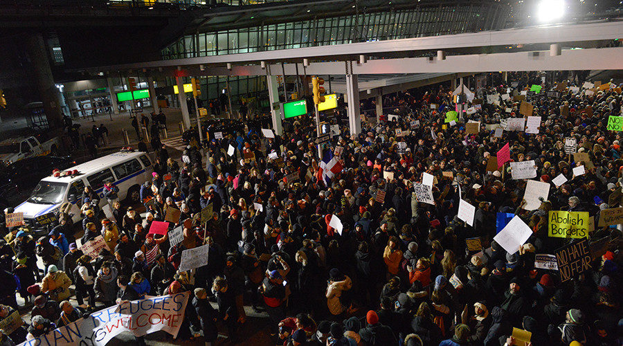 Protestors rally during a demonstration against the new immigration ban issued by President Donald Trump at John F. Kennedy International Airport on January 28, 2017 in New York City