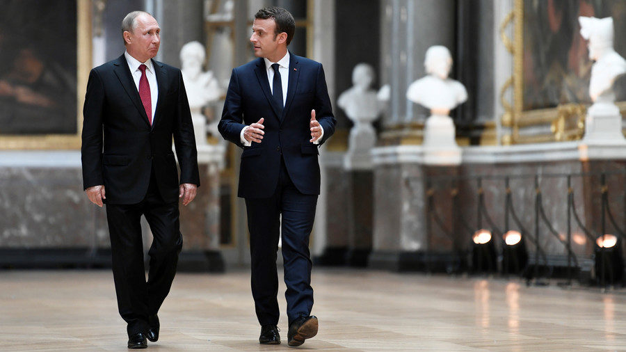 Emmanuel Macron (R) speaks to Vladimir Putin