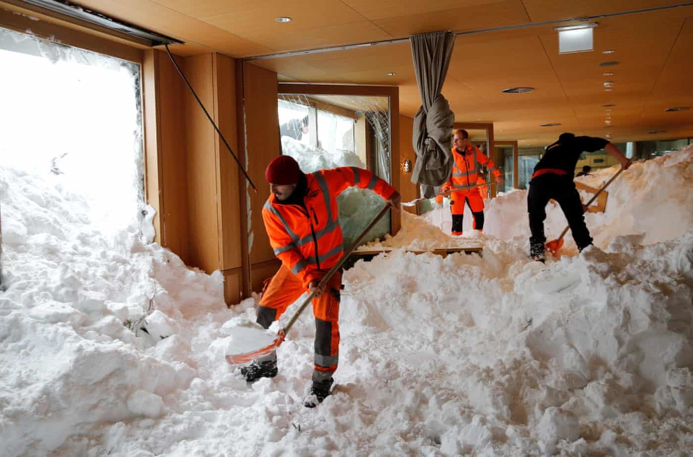 Workers shovel snow out of a restaurant after