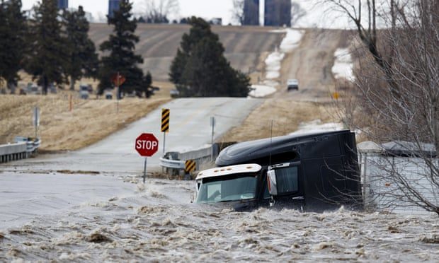 A semi truck and trailer are swept off the road by floodwaters in Arlington, Nebraska
